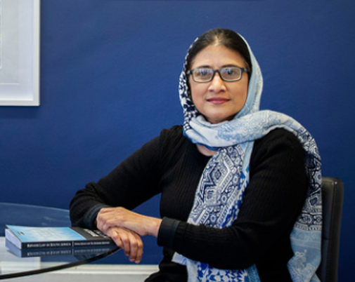 Professor facing camera, with spectacles, wearing a hijab