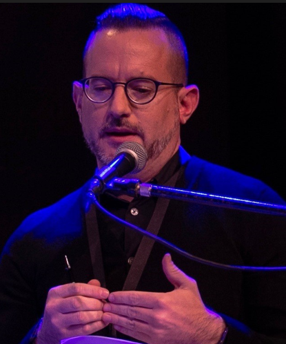 Professor speaking at podium with microphone at mouth