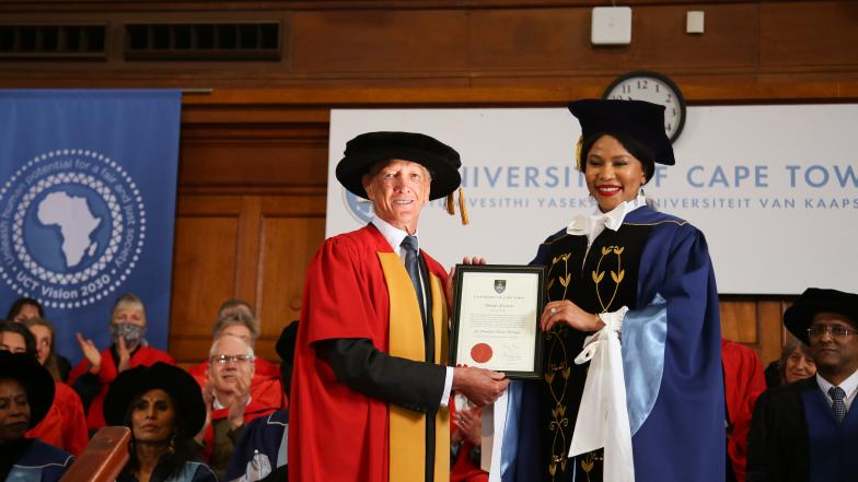 Berman and the Chancellor in grad gowns holding the certificate