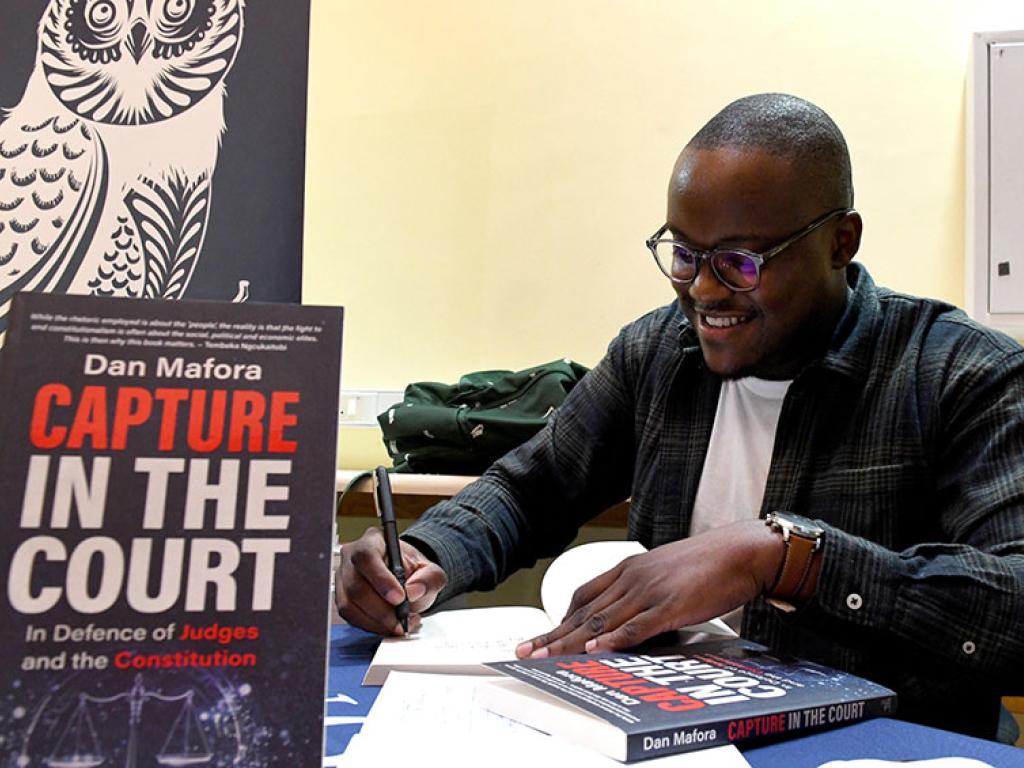Dan Mafora signs copies of his new book