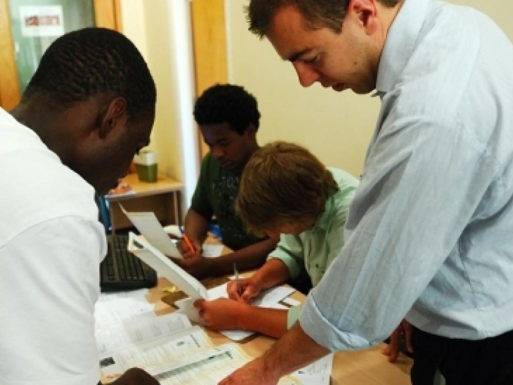 group of staff working on refugee matters around a desk