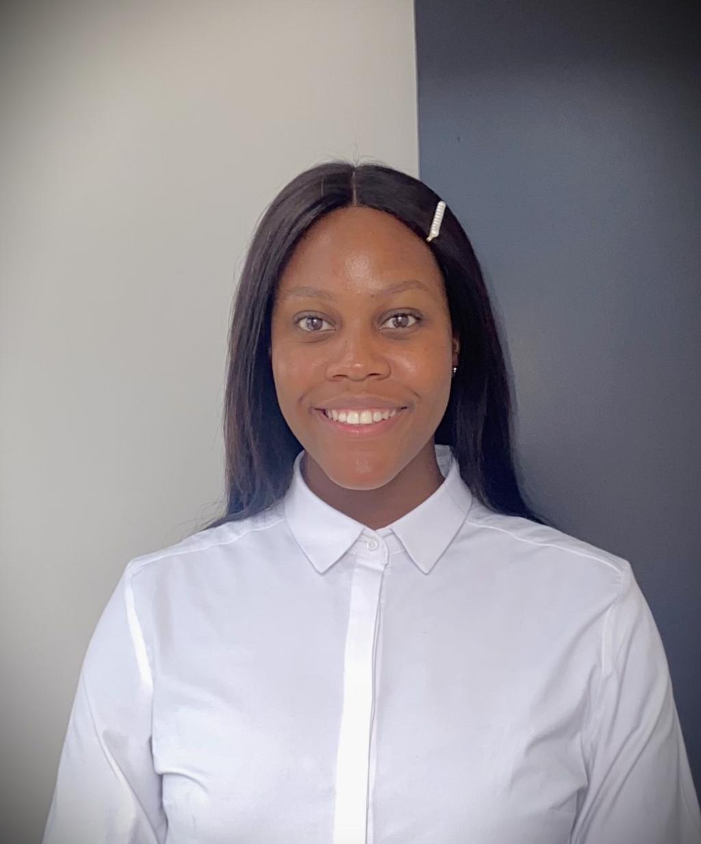 Thato Muzola stands against a grey and white background